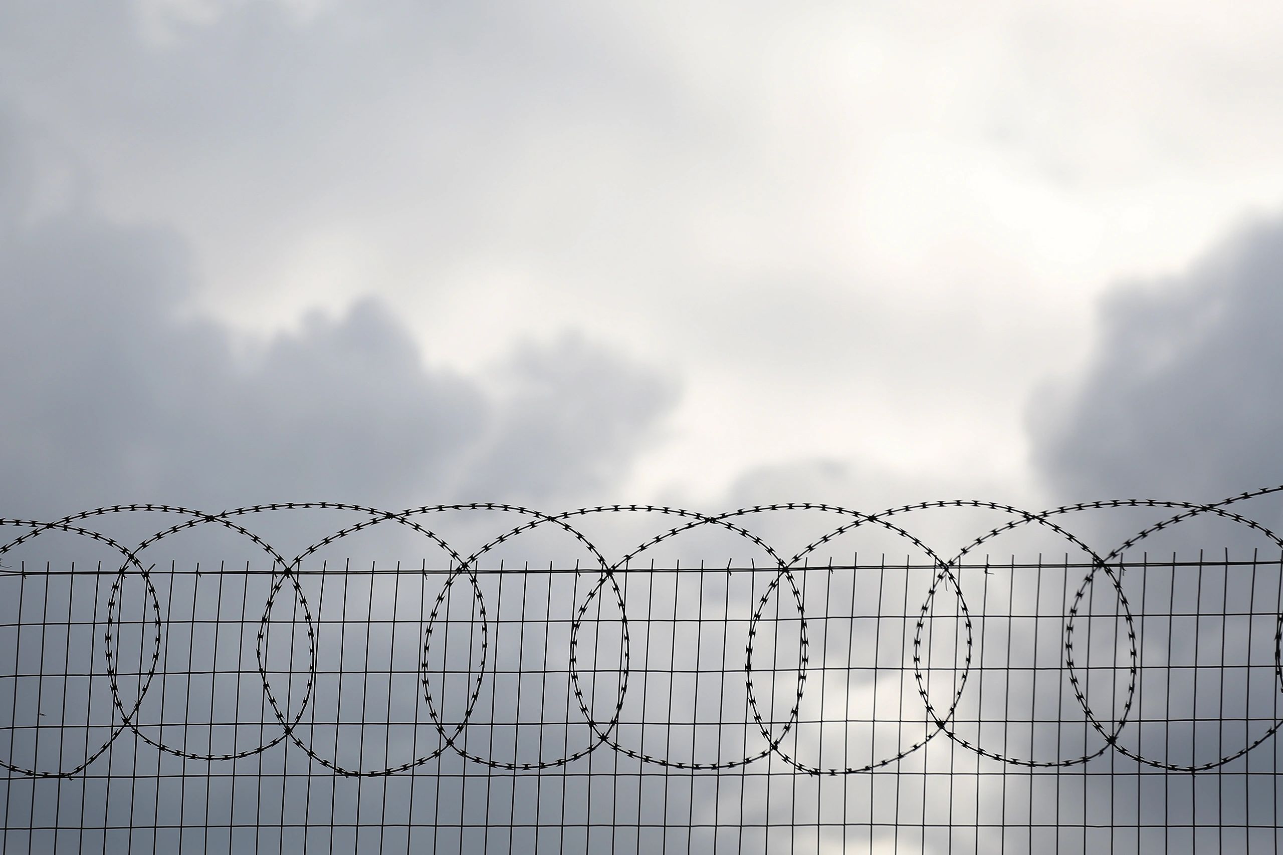 Security fence silhouette with razor wire