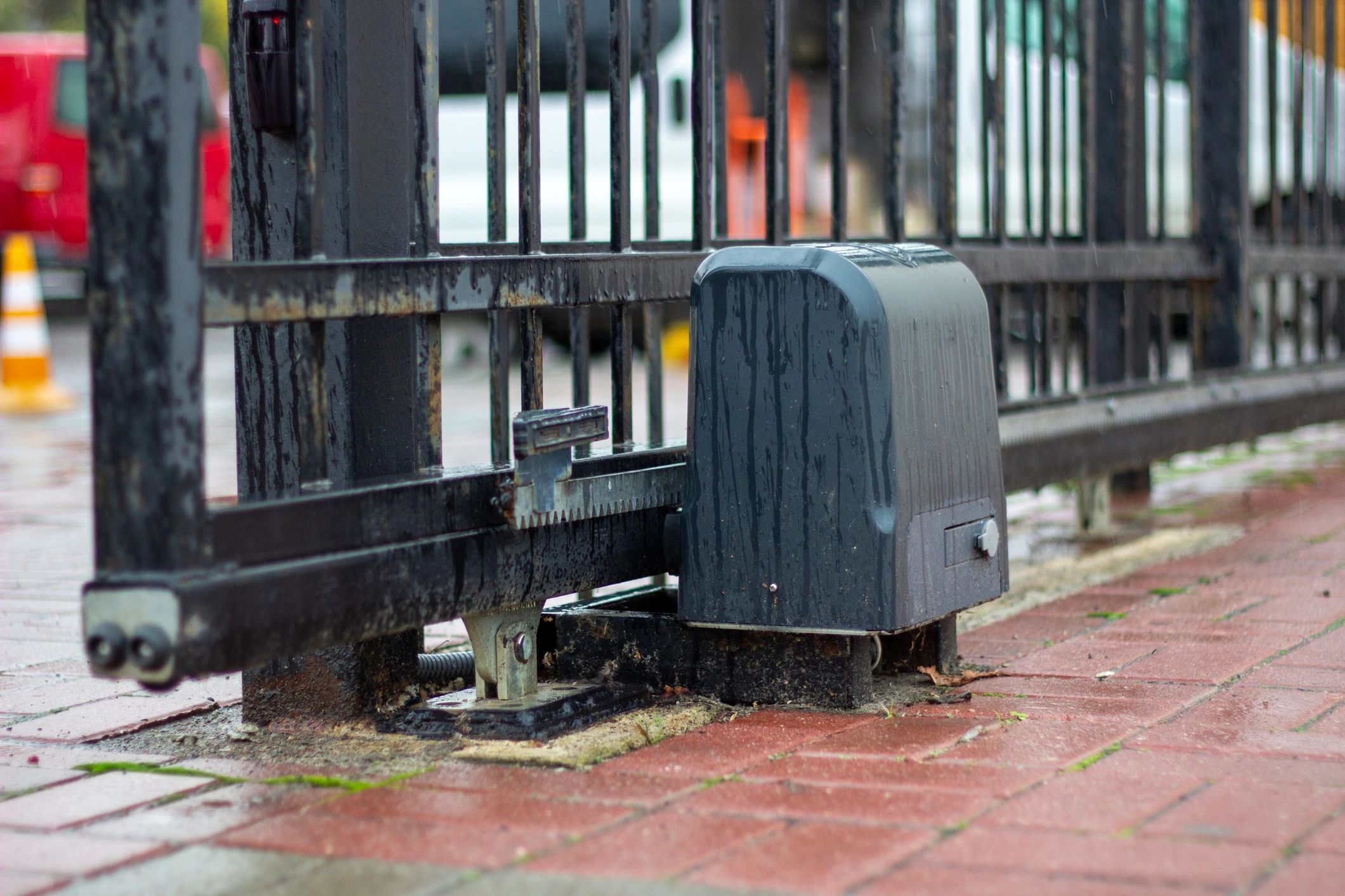 Automatic gate opener arm on wrought iron driveway gate