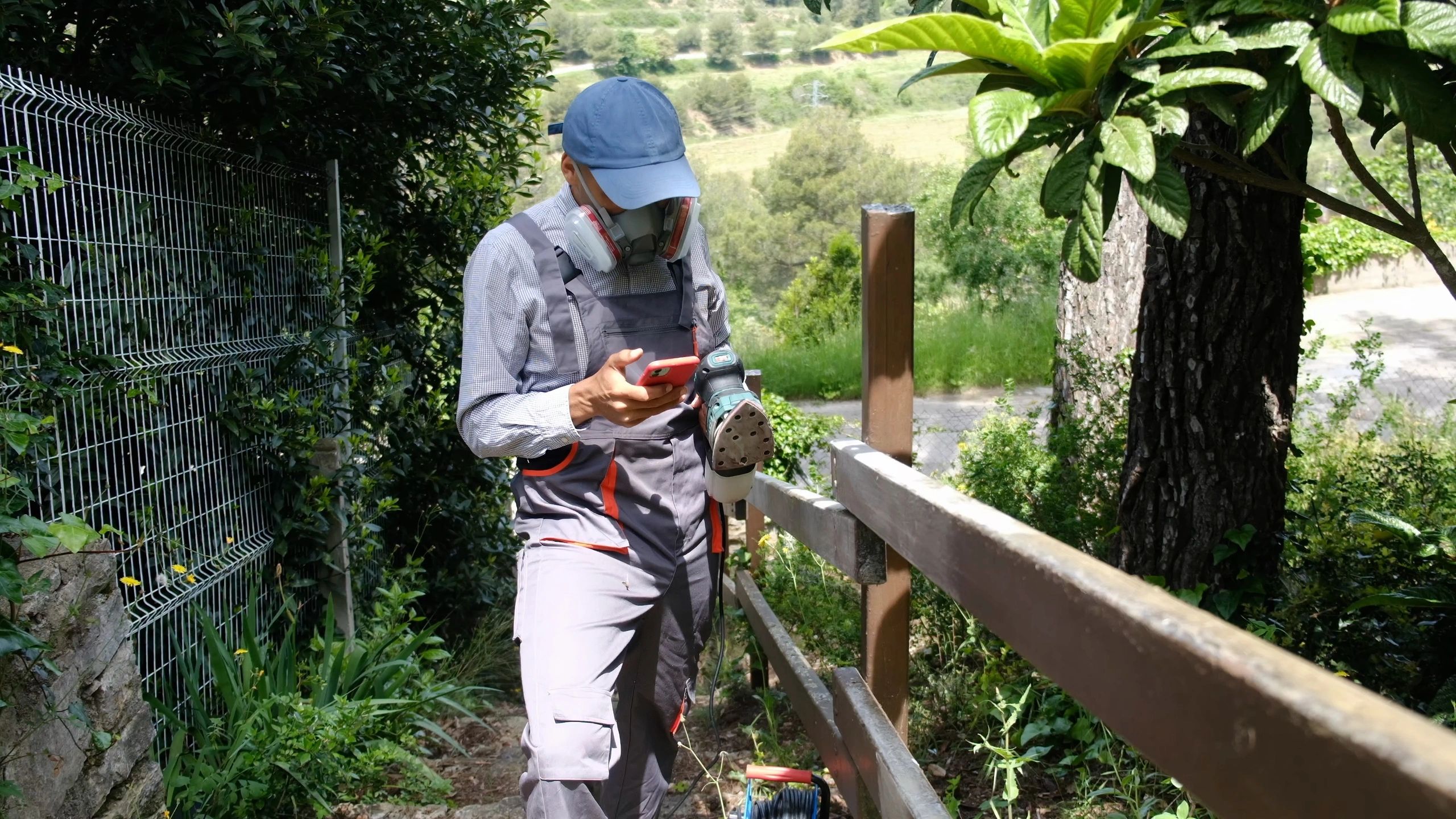 Worker sanding a wooden fence during finishing